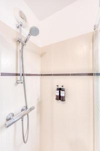 a shower with a shower head in a bathroom at L'Écrin Piano, chic near Paris in Asnières-sur-Seine