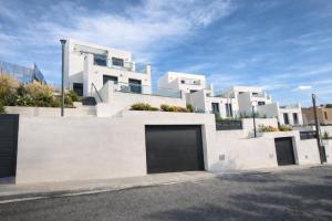 a large white house with a garage at Les Flors de Cunit Villa Cedra in Cunit