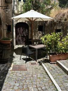 a patio with a table and an umbrella at Residenza La Torre in Santo Stefano di Sessanio