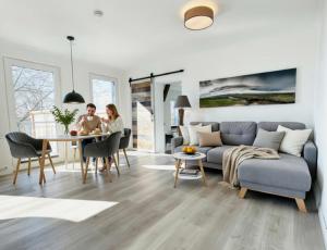 two people sitting at a table in a living room at Hof Steinhütten Boutique Apartments in Westerhever