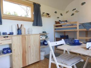 a room with bunk beds and a table and a chair at Schäferwagen Gartenblick Nr 4 in Radebeul