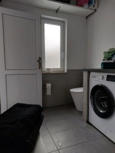 a bathroom with a washing machine and a window at Schäferwagen Gartenblick Nr 4 in Radebeul +6 photos