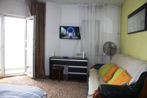 a living room with a couch and a tv on the wall at decebal premium apartment in Bucharest