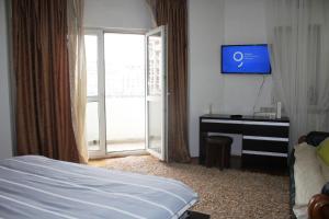 a bedroom with a bed and a tv and a window at decebal premium apartment in Bucharest +2 photos