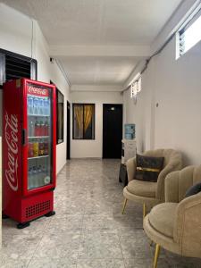 a cocacola soda machine in a room with chairs at Hotel SR, Villa Garzón in Villagarzón +19 photos