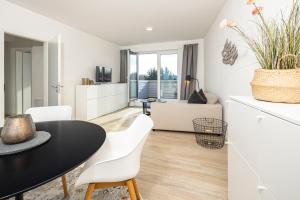 a living room with a black table and white chairs at Ostsee Suite 1 - Strandperle in Niendorf