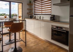 a kitchen with white cabinets and a table and chairs at Loveli Stay Aruba in Oranjestad