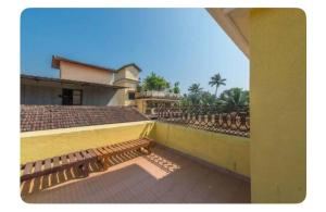 a view of a balcony of a building with a bench at Avis Home in Calangute