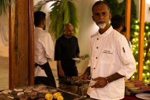a chef standing in front of a table with food at Shallow Lagoon Sunset in Rasdhoo