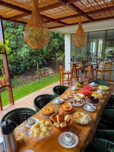 a long wooden table with food on it at Costa do Sauípe 5 suítes, piscina, hidromassagem e área de lazer completa in Mata de Sao Joao