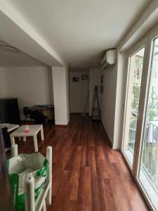 a living room with wooden floors and a large window at L'Amplesso xxx in Bari