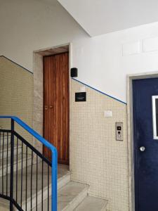a hallway with a blue door and a staircase at L'Amplesso xxx in Bari +4 photos