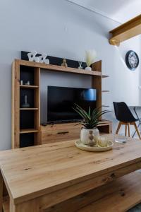 a living room with a wooden table with a television at Messolonghi Holy City in Missolonghi