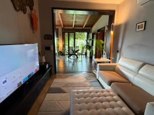 a living room with a couch and a flat screen tv at Casagiardino Sofía in Marina di Varcaturo