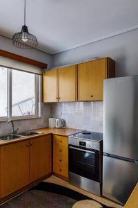 a kitchen with wooden cabinets and a stainless steel refrigerator at Messolonghi Holy City in Missolonghi +14 photos