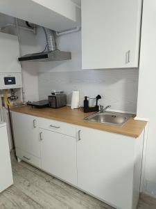 eine Küche mit weißen Schränken und einer Spüle in der Unterkunft Harmony Studio in Târgu Secuiesc