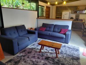 a living room with two blue couches and a coffee table at Loft com piscina, sauna e hidro in Niterói