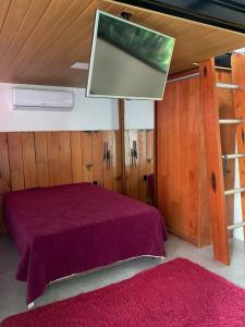 a bedroom with a purple bed and a red rug at Loft com piscina, sauna e hidro in Niterói