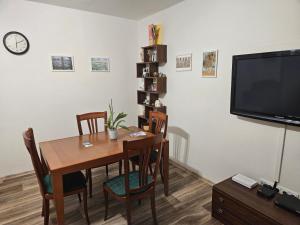 a dining room with a table and a tv at Olé in Zlatá Olešnice