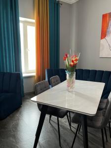 a room with a table with a vase of flowers on it at Aq-Jaiyq Halal Hotel in Karagandy