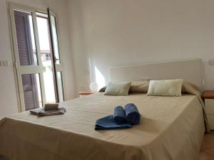 a bed with two pairs of blue towels on it at Casa FLORE in Orosei