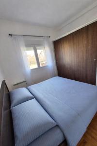 ein Schlafzimmer mit einem großen blauen Bett und einem Fenster in der Unterkunft Teja- new apartment for 4 person with free parking space in Belgrad + 6 Fotos