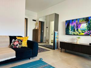 a living room with a couch and a tv on the wall at Caro Studio in Tunari