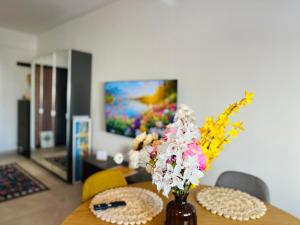 a vase of flowers on a table in a room at Caro Studio in Tunari