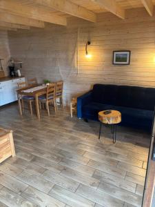 a living room with a blue couch and a table at Chaty Mazur w Wierzbie in Ruciane-Nida