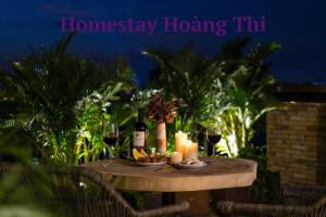 a table with candles and wine glasses on it at Homestay Hoàng Thi in Phan Thiet