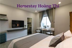 a bedroom with a bed and a television and a table at Homestay Hoàng Thi in Phan Thiet
