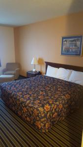 a hotel room with a large bed and a chair at The Rutledge Inn in Luverne