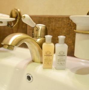 a bathroom sink with two bottles of moisturizers on it at Хотел ЛОНДОН in Svilengrad