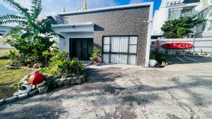 a house with a driveway in front of it at 花一村の宿 Huayicun Homestay in Hengchun South Gate