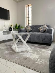 a living room with a couch and a table at Modern staycation -ruaka in Ruaka