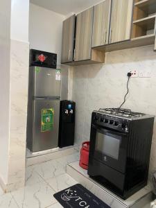 a kitchen with a stove and a refrigerator at Modern staycation -ruaka in Ruaka