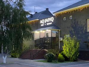 a building with a sign on the front of it at Aq-Jaiyq Halal Hotel in Karagandy