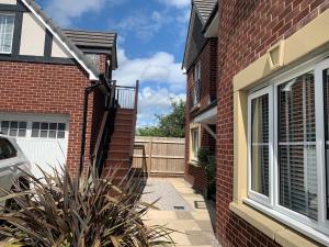 a brick house with a driveway and a white garage at Loft Studio in Davenham