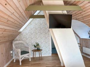 a living room with a tv and a chair and a table at Hotel Strandgaarden in Vesterø Havn