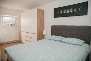 a bedroom with a large bed with a blue blanket at Deniro Apartment in Požega