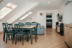 a dining room with a table and chairs and a couch at Deniro Apartment in Požega