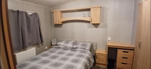a small bedroom with a bed and a cabinet at Accessible and dog friendly caravan in Ingoldmells