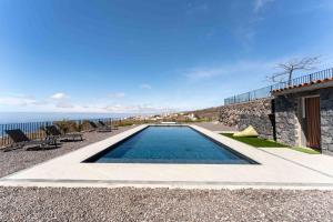 a swimming pool in front of a house with the ocean at Finca el Vinche in Guía de Isora +67 photos