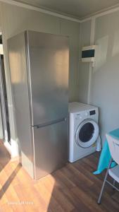 a kitchen with a refrigerator and a washing machine at Anastasi Tiny Homes- Mountain Views, Garden & Terrace, Pet Friendly in Kakopetria