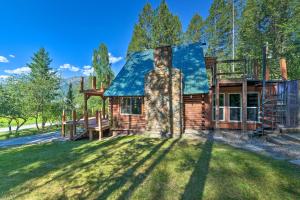 a log cabin with a blue roof at Alpine Adventures: Cozy Log Cabin w/ Deck & Views! in Alpine