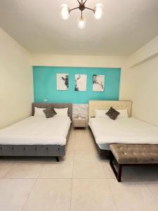 two beds in a room with blue walls at Aliwan 小路彎彎 in Taitung City