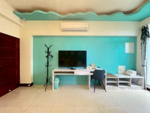 a room with a desk and a blue wall at Aliwan 小路彎彎 in Taitung City