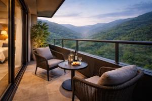 a balcony with a table and chairs and a view at Travellers Story Baga GOA in Baga