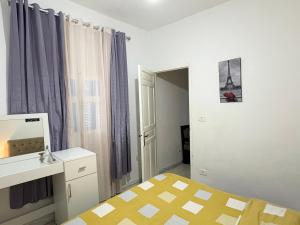 a bedroom with a bed and a desk and a mirror at Appartement Ettahrir in Tunis