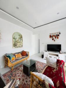 a living room with a couch and a tv at Villa Suarga Loka in Tutugan